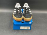 adidas superstar shoes in a box on a grey surface