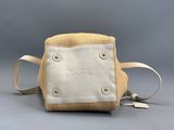 sac à main beige et blanc muni d'une bandoulière, sur fond gris