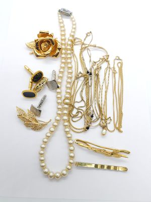 a lot of gold and silver jewelry on a white surface