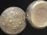 une boîte en argent sur laquelle figure le portrait d'une femme