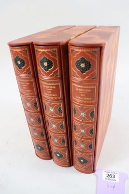 trois livres sont empilés sur une surface blanche