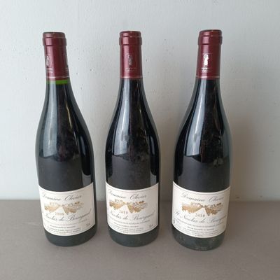 three bottles of wine sit on a table next to each other