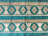 une image représentant un tissu vert et doré orné d'un motif