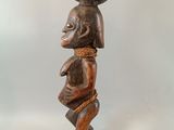 une image représentant une statue en bois d'un homme portant un bol sur la tête