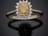 une bague sertie d'un diamant jaune et blanc sur un fond noir
