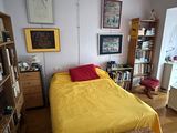 yellow bedspread on a bed in a bedroom next to a book shelf
