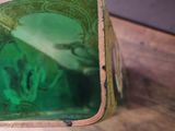 someone is holding a green bag with a picture of a man on it