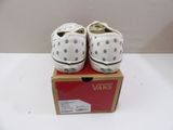 pair of white vans sneakers with polka dots on them sitting on a box