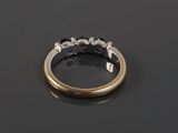 a gold ring with blue sapphires and diamonds on a black surface
