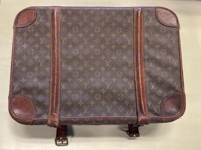 a brown suitcase sitting on top of a white table