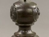 a bronze statue of a man sitting on top of a pedestal