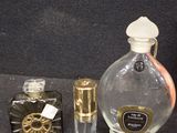 many different perfume bottles on a table with a black background