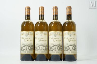 quatre bouteilles de vin sont alignées sur une surface blanche