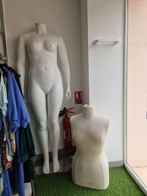 a mannequin in the corner of a room next to a window