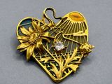 an image of a gold heart shaped brooch with a flower inside