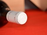 a bottle of wine sitting on a table with a red cloth