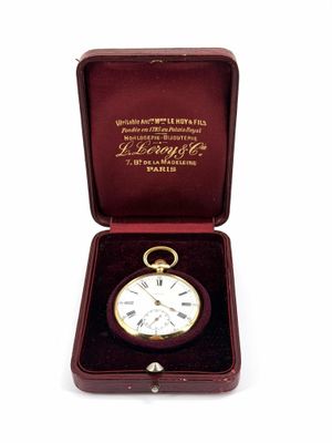 une boîte avec une montre à l'intérieur sur une surface blanche