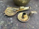 une cuillère en laiton et une théière posées sur une table