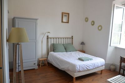 une chambre avec un lit, une commode et une fenêtre