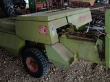 une machine verte qui est à l'arrêt dans la poussière