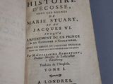 an open book on a blue surface with a black and white title