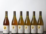 six bouteilles de vin sont alignées sur une table en bois
