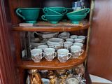 de nombreuses tasses et soucoupes posées dans un coin de ce placard