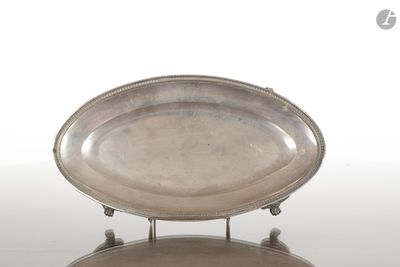 un plateau d'argent antique sur un support sur une surface blanche