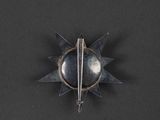 an image of a metal pin with spikes on a black surface