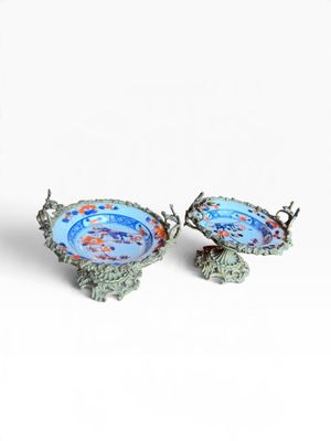 une paire d'assiettes bleues et vertes ornées de poissons sur un fond blanc