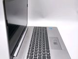 a silver laptop with a black keyboard on a white surface