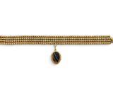 un bracelet en or orné d'un pendentif en pierre noire