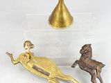 a gold statue of a woman and a deer next to a gold vase