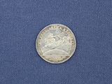 a close up of a silver coin on a blue cloth