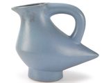 un vase bleu muni d'une anse incurvée sur fond blanc