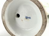 a white vase with a blue and white design on it