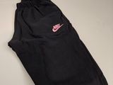 a black nike sweat pants with pink logo on the side