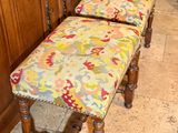 a bench with a colorful upholstered seat next to a cabinet