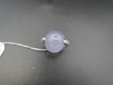 une image représentant une bague ornée d'une pierre violette sur un fond noir