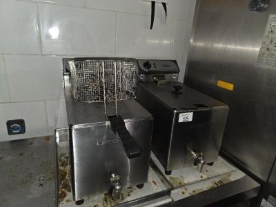 two deep fryers sitting on a counter in a kitchen