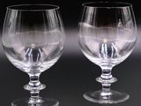 two empty wine glasses sitting next to each other on a table