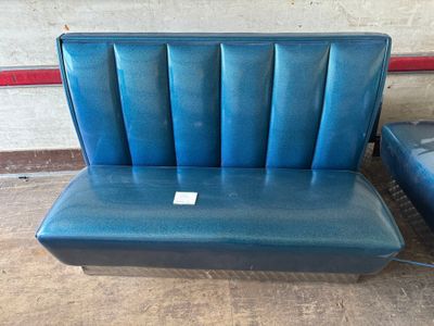 a blue bench and a black chair in a room