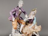deux figurines d'un homme et d'une femme assis sur un rocher