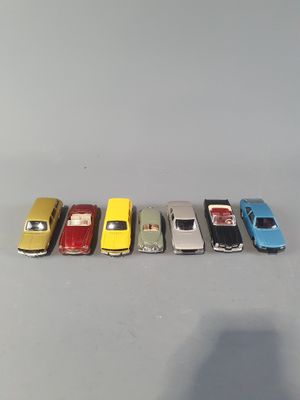 several toy cars are lined up in a row on a gray surface