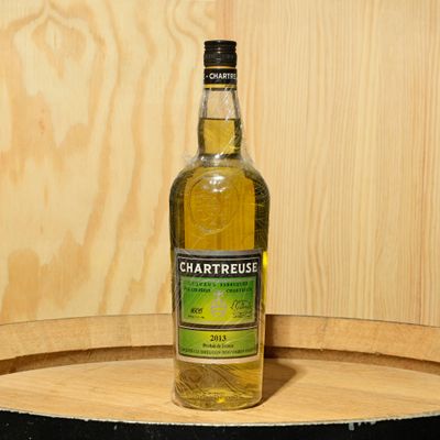 a bottle of chartreusus sitting on top of a barrel