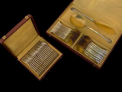 deux sets d'argenterie dans un coffret sur une table