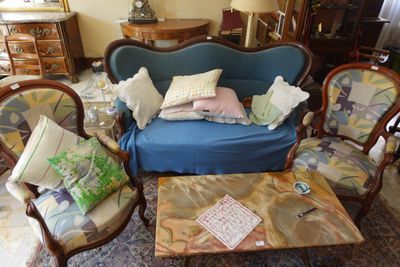 un canapé bleu placé dans un salon, à côté d'une table basse