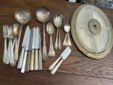 a lot of silverware on a wooden table