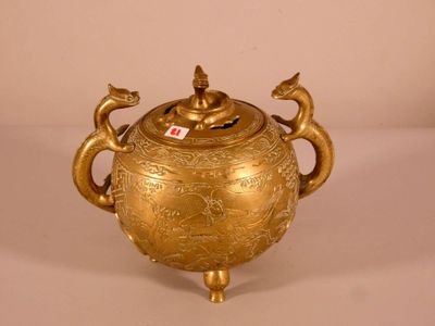 a gold teapot with two birds on top of it