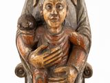 an old wooden statue of a woman holding a baby and a bird